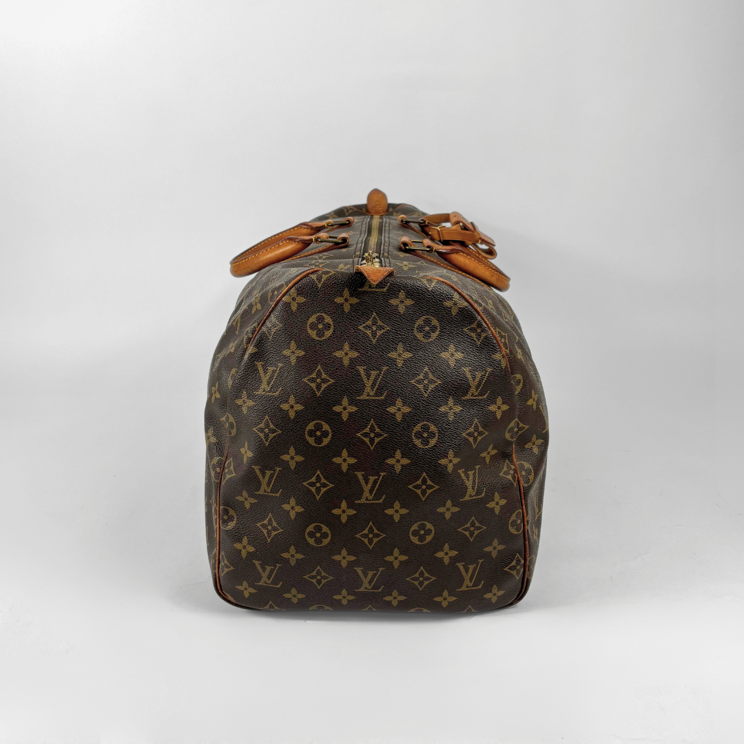 Brown Louis Vuitton travel bag with monogram pattern on a white background