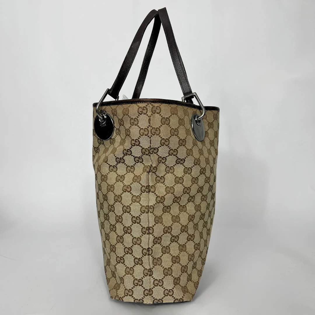 Designer handbag with monogram pattern on a light gray background