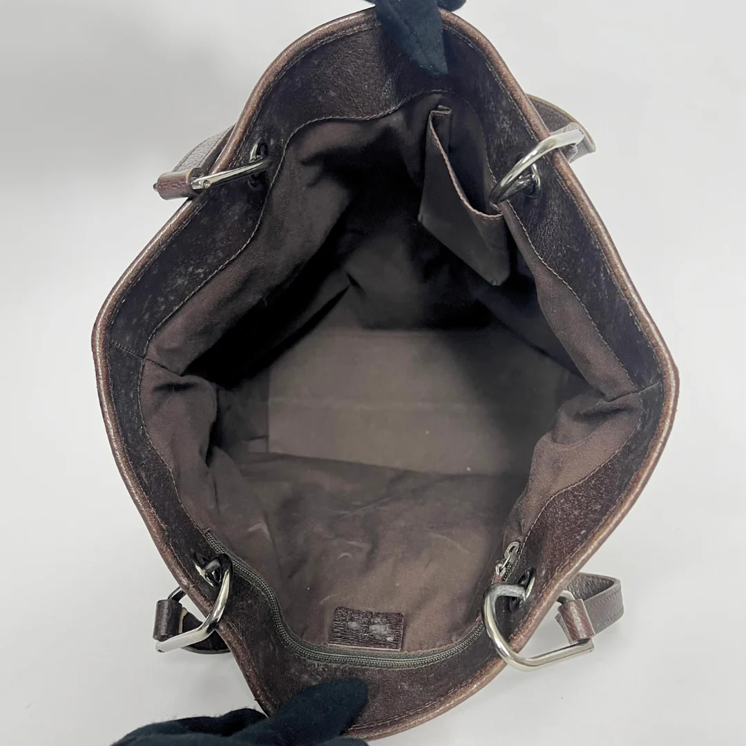 Brown leather bag with visible stitching on a white background