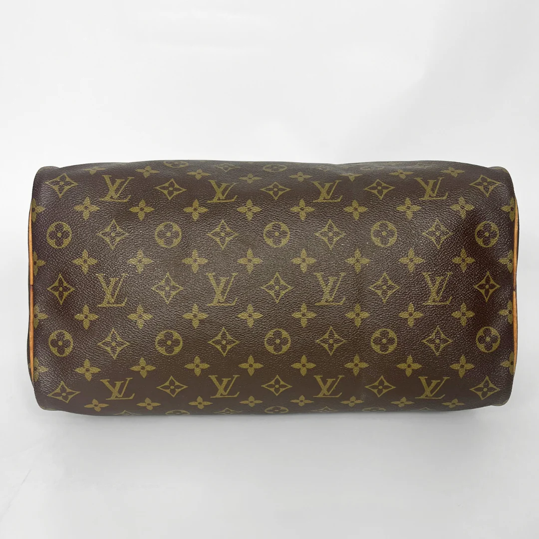 Brown leather bag with gold monogram pattern on a white background