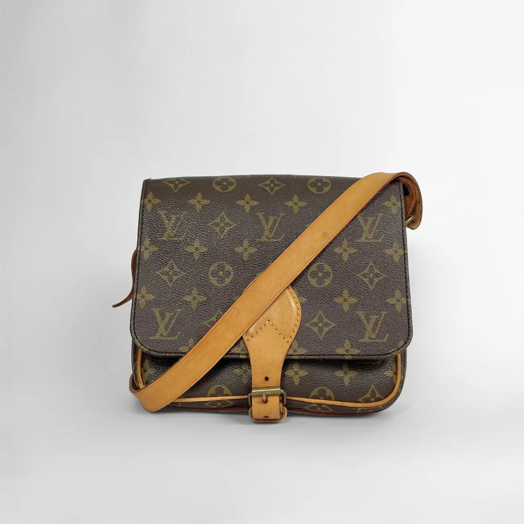 A vintage Louis Vuitton monogram canvas shoulder bag with tan leather trim and strap, photographed on a neutral light gray background.