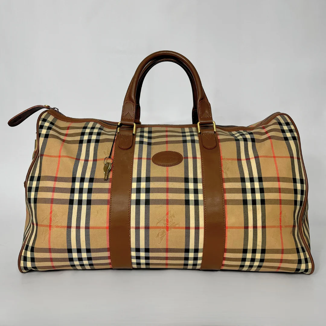 Plaid patterned bag with brown straps on a gray background