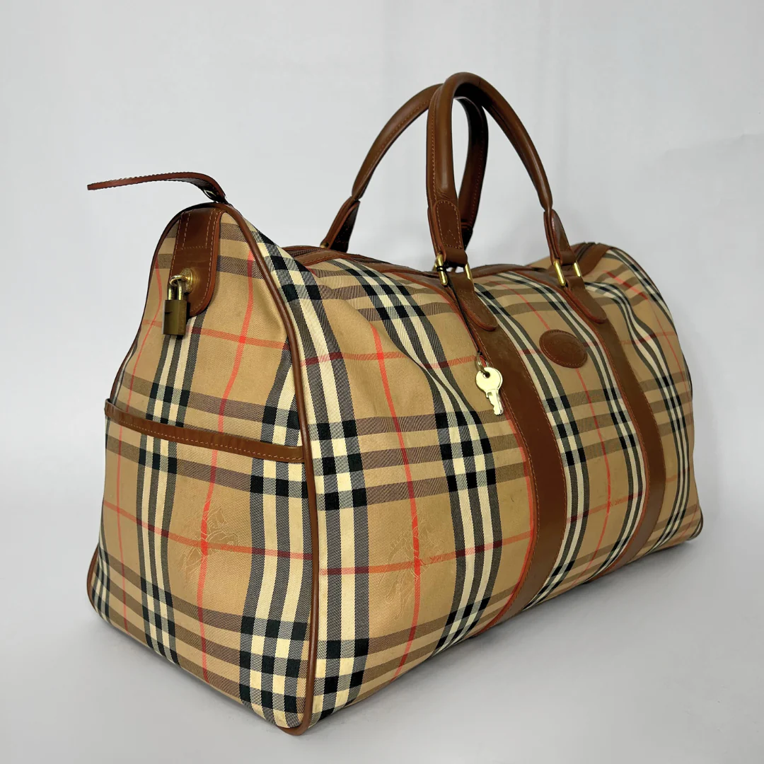 Plaid patterned bag with brown handles on a light gray background