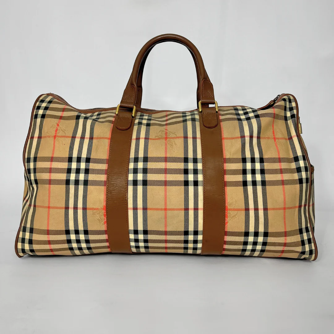 Plaid bag with brown leather straps on a gray background