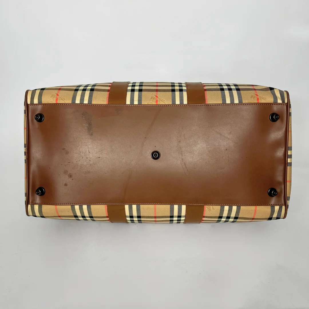 Brown leather clutch with plaid pattern on a light gray background