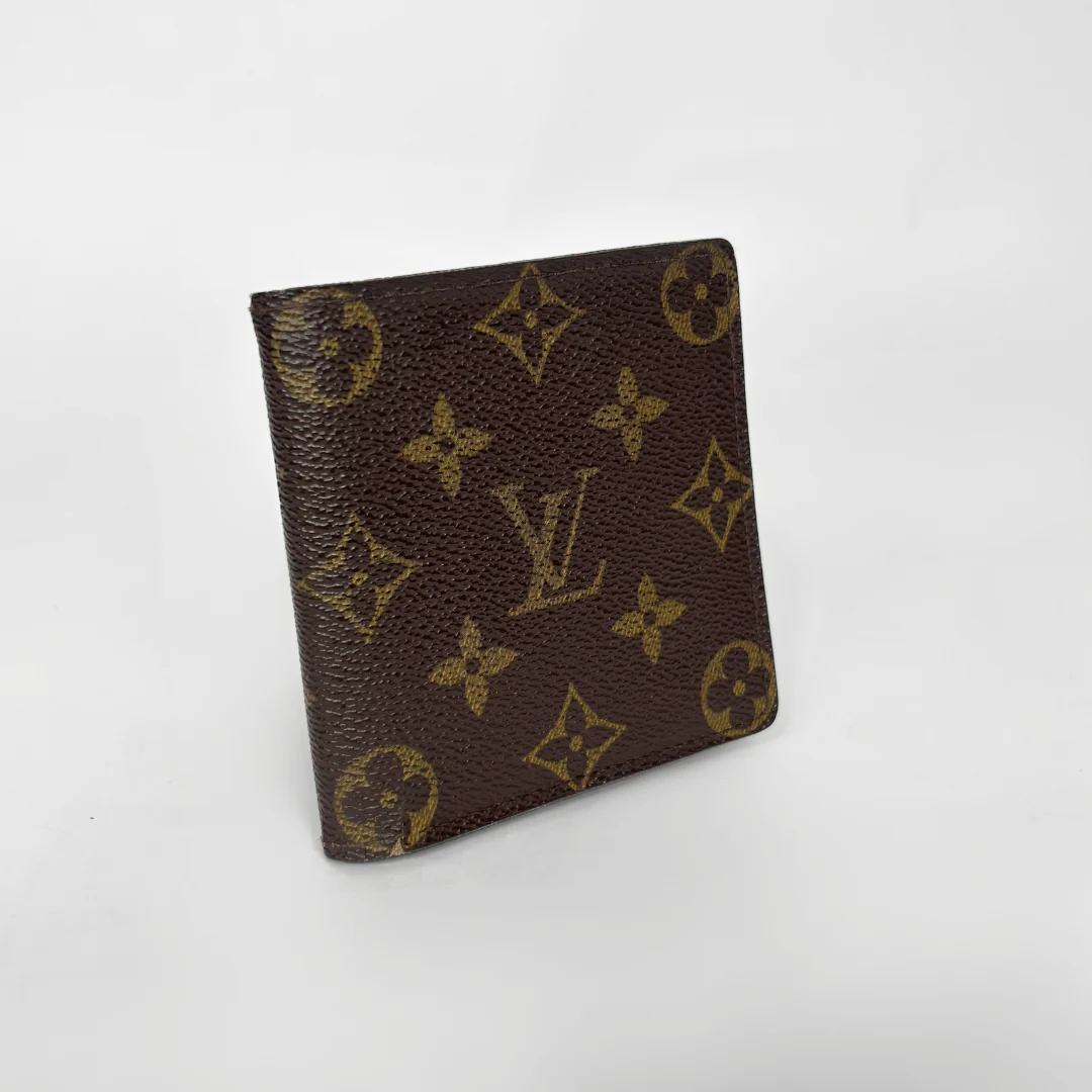 Brown wallet with gold monogram pattern on a white background