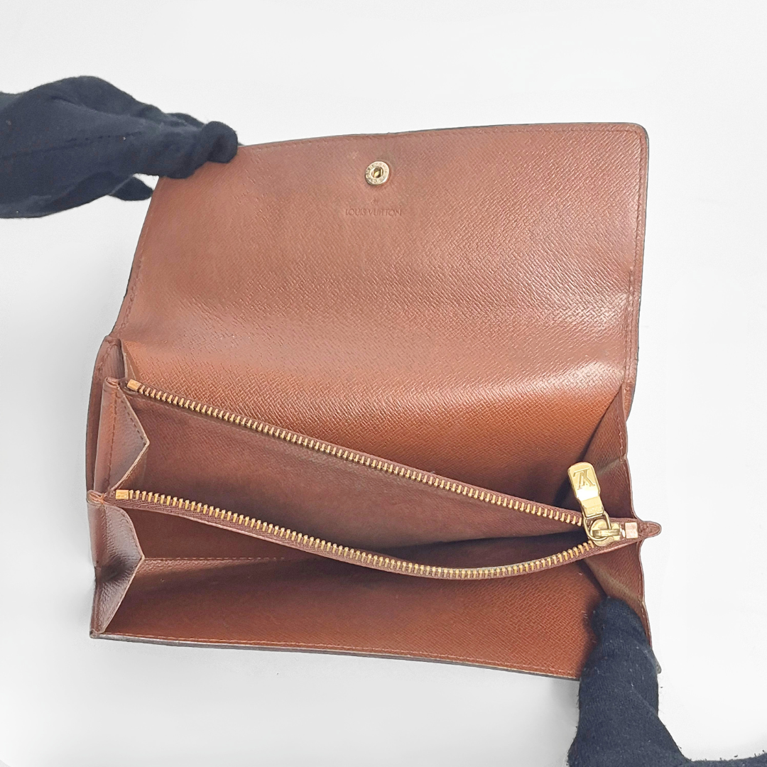 Brown leather handbag with gold zipper on a white background