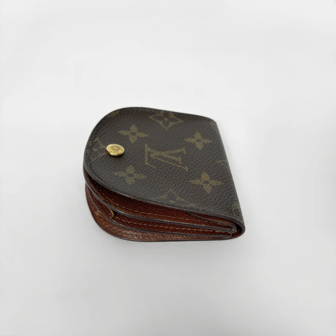 Louis Vuitton wallet with monogram pattern on a white background