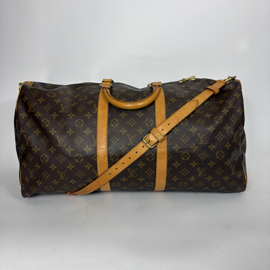 Brown monogram duffel bag with tan leather straps on a white background