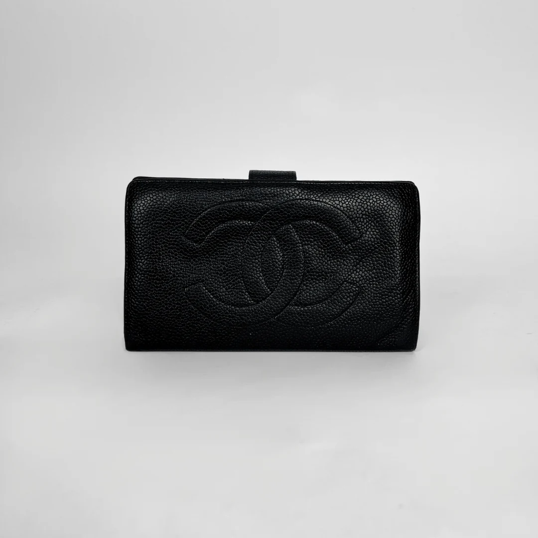 A black textured leather clutch wallet featuring an embossed interlocking CC logo, characteristic of Chanel, set against a plain light gray background.