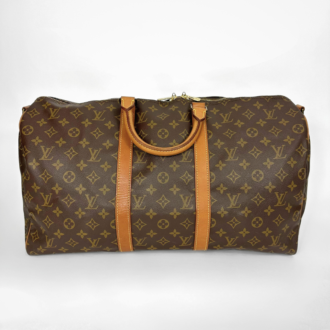 Brown travel bag with tan handles and trim on a white background