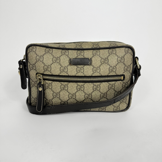 Gucci handbag with monogram pattern on a light gray background