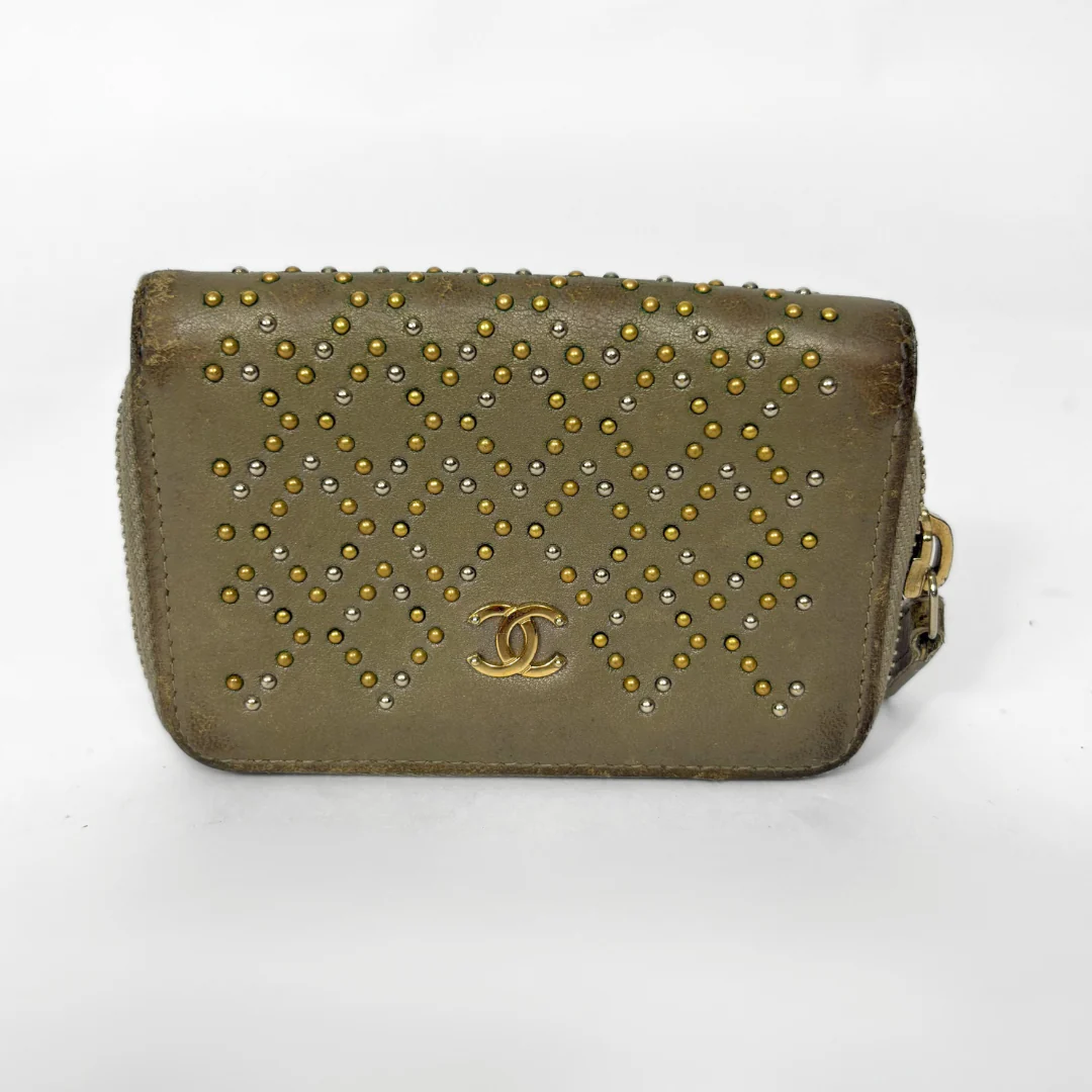 Green handbag with gold studs and Chanel logo on a white background