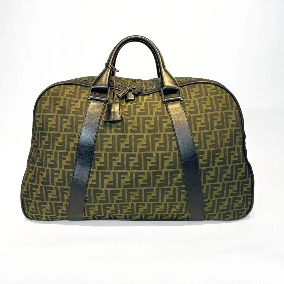 Green patterned suitcase with black straps on a white background