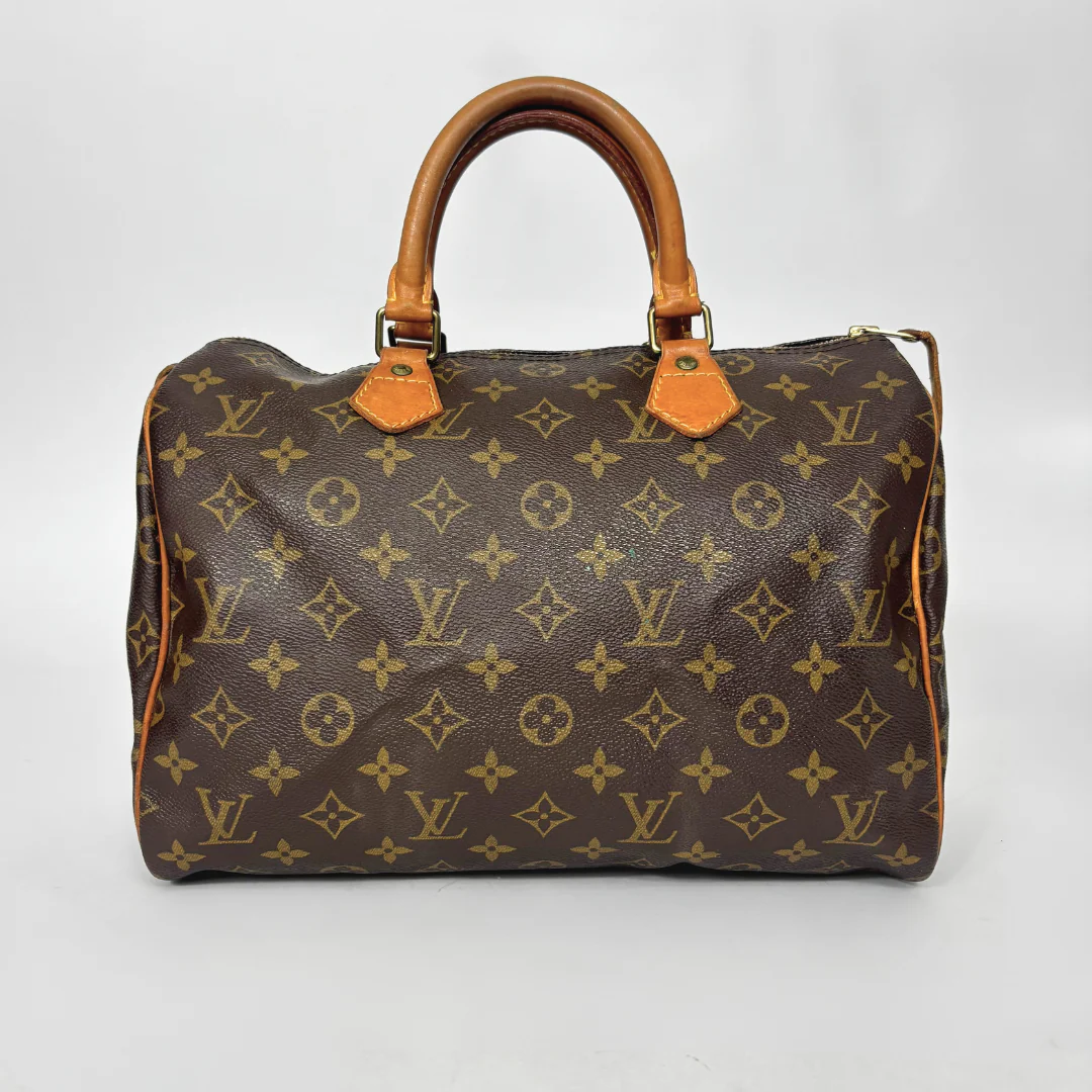 Brown handbag with gold monogram pattern on a white background