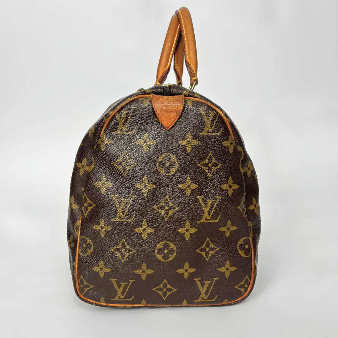 Brown handbag with monogram pattern on a white background