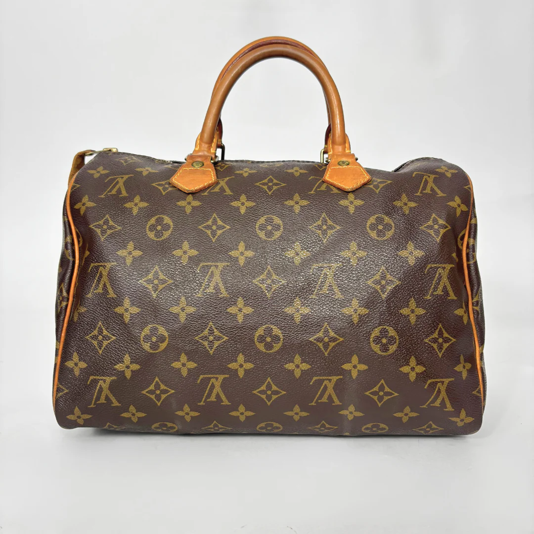 Brown handbag with yellow monogram pattern on a white background