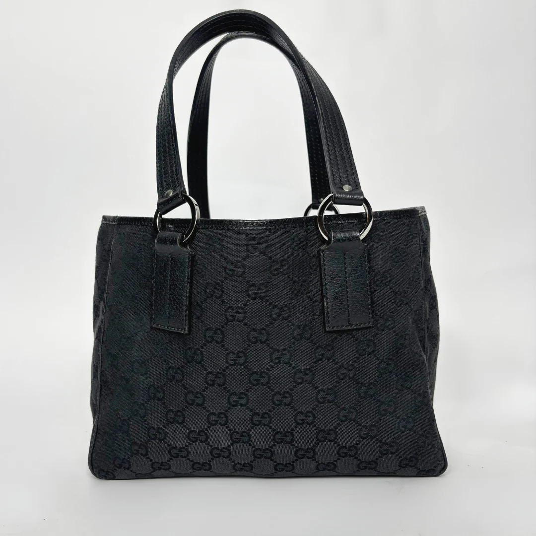 Black textured handbag with brand logo on a white background