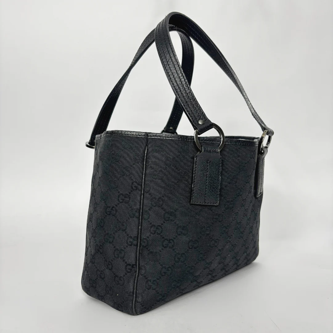 Black textured handbag on a light gray background