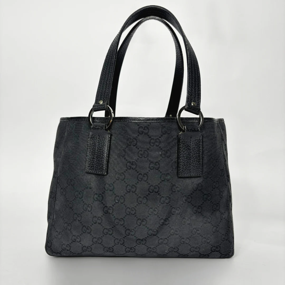 Black handbag with a pattern on a white background