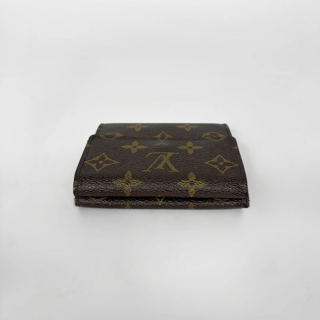Brown wallet with gold monogram pattern on a white background
