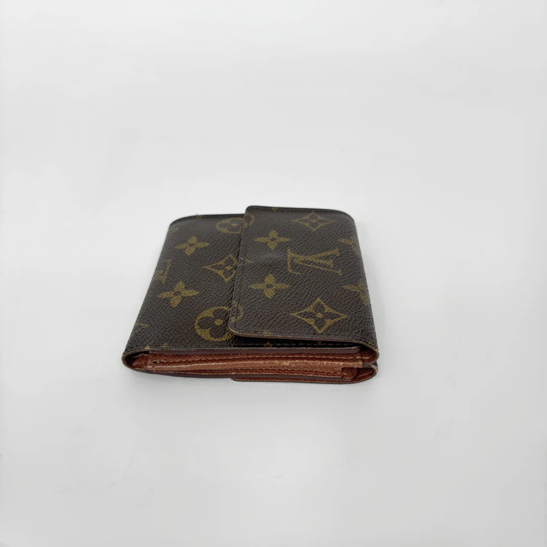 Louis Vuitton wallet with monogram pattern on a white background