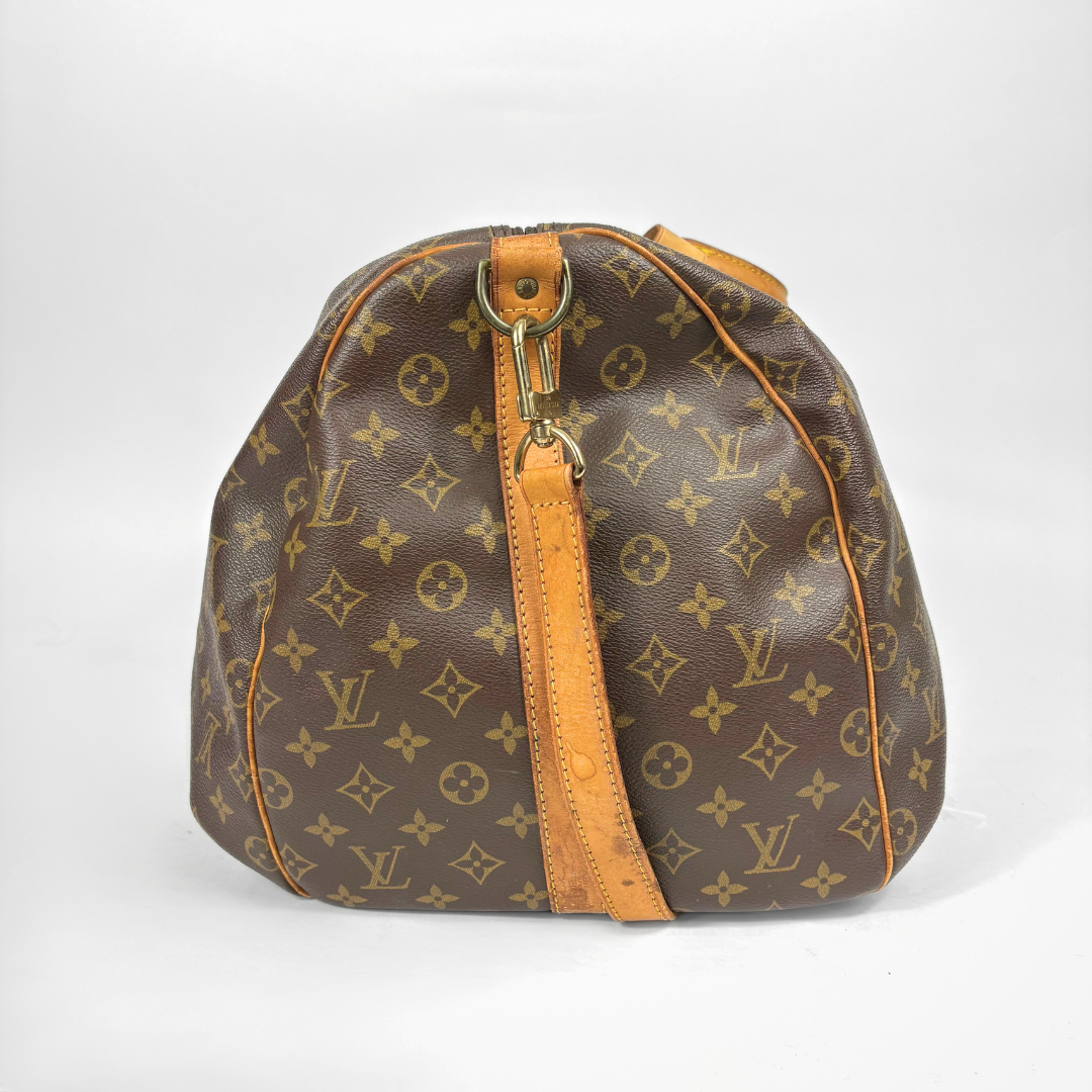 Brown duffel bag with tan leather straps and handle on a white background