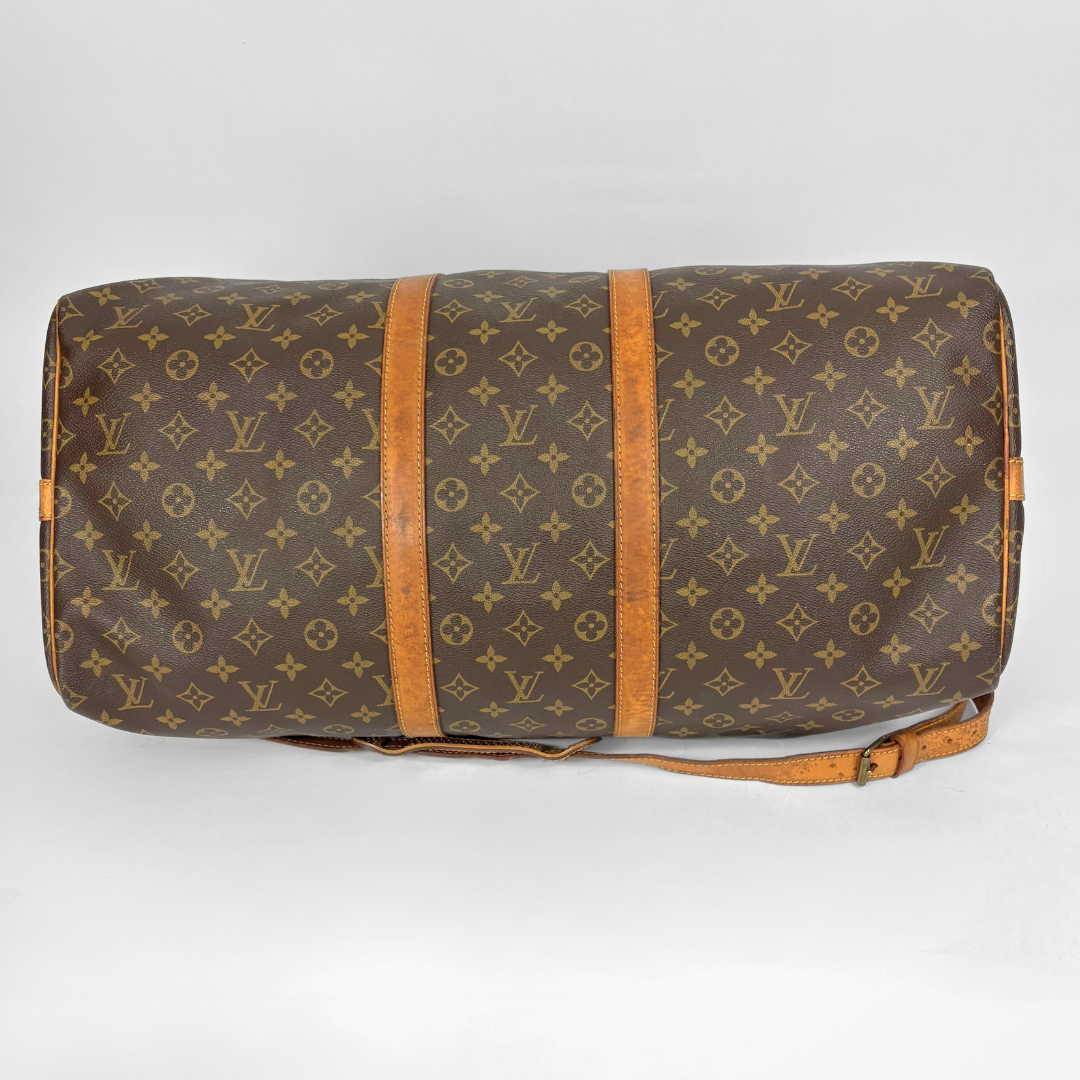 Brown duffel bag with tan leather straps and handle on a white background