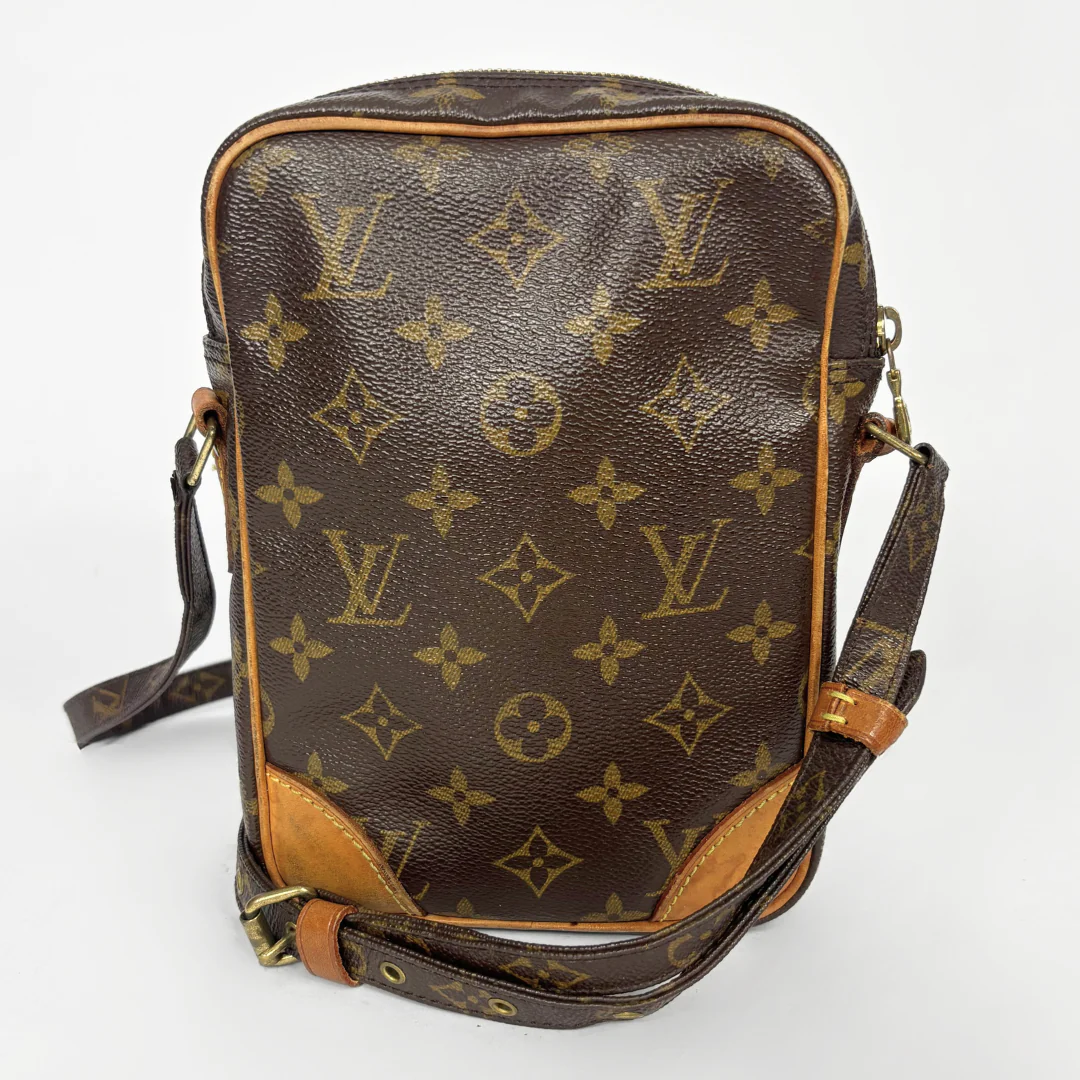 Brown leather bag with gold monogram pattern on a white background