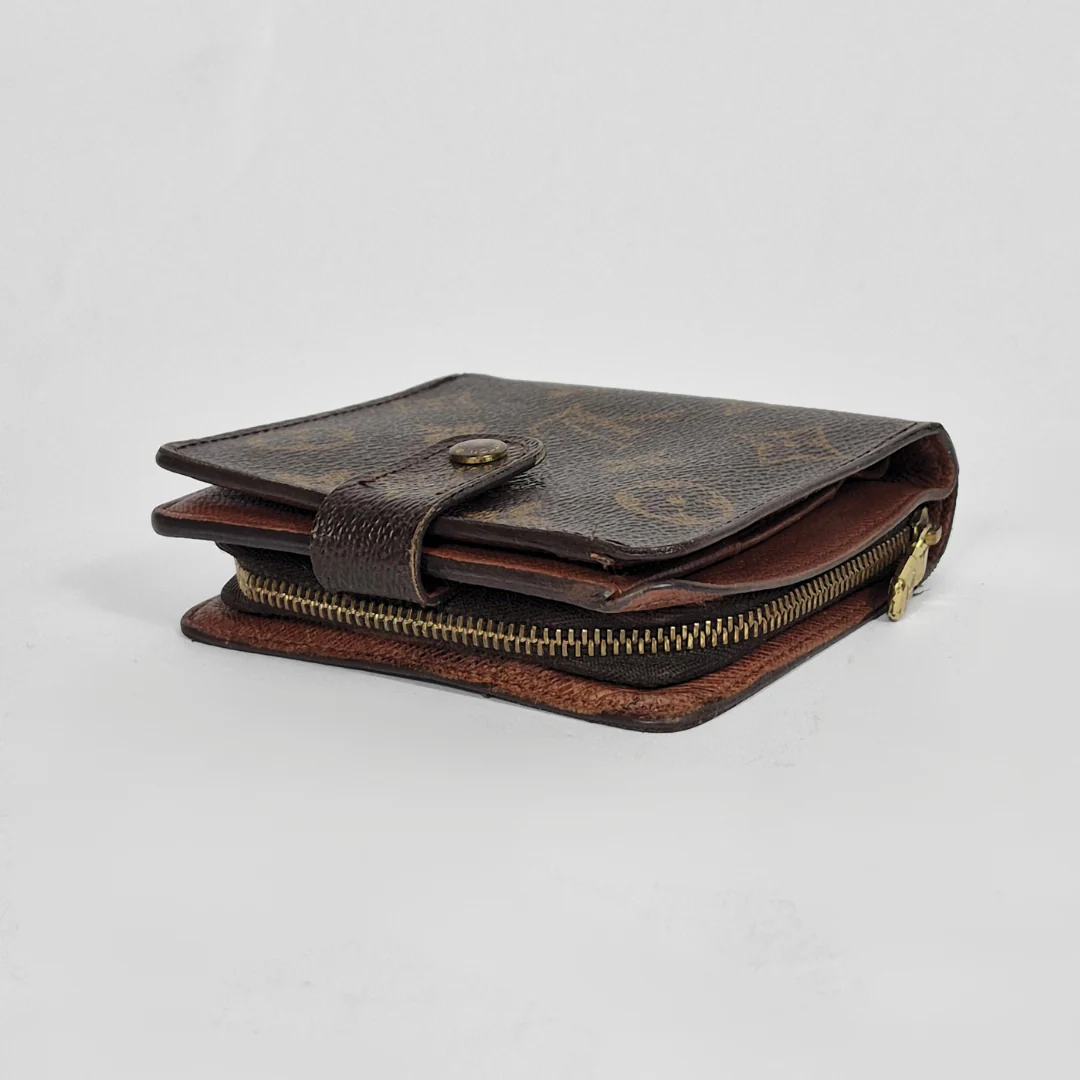 Brown leather wallet with gold zipper on a light gray background