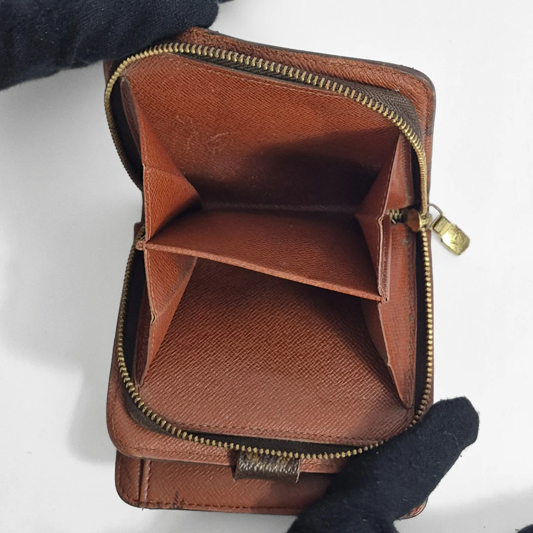 Brown leather wallet with gold zipper on a white background