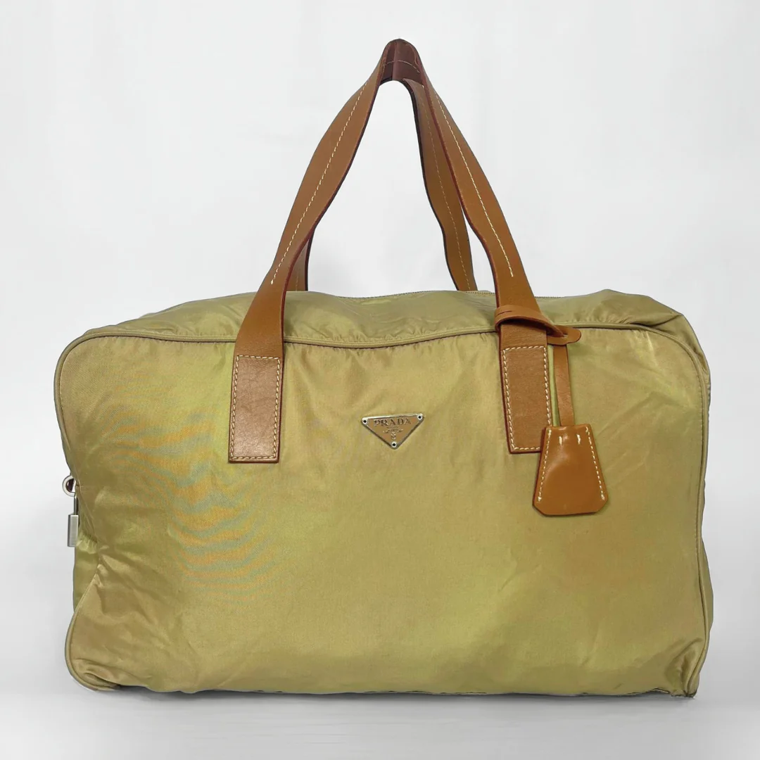 Green travel bag with brown handles on a white background