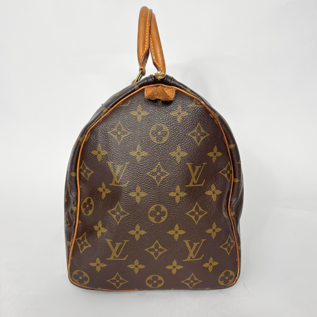 Brown handbag with monogram pattern on a white background
