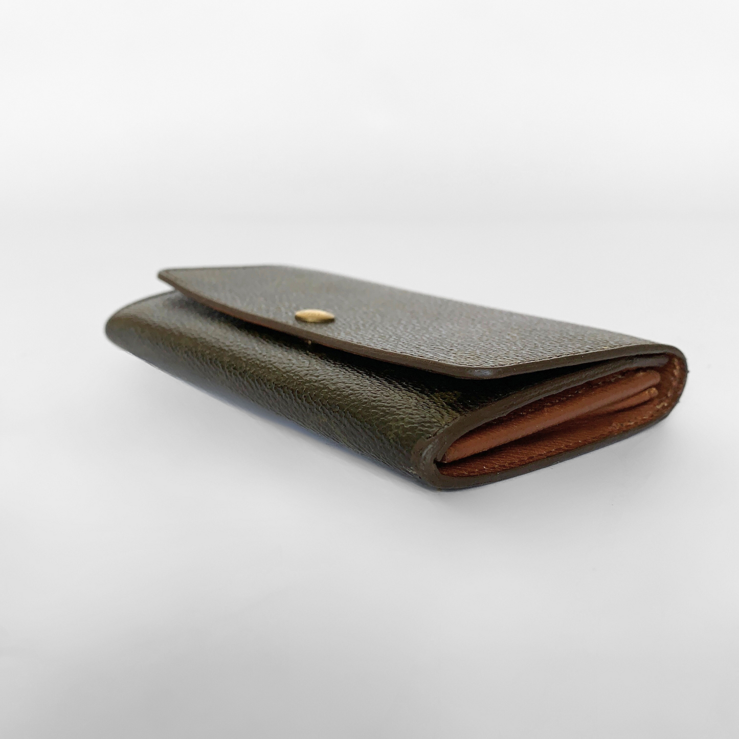 Black leather wallet with a gold button on a white background