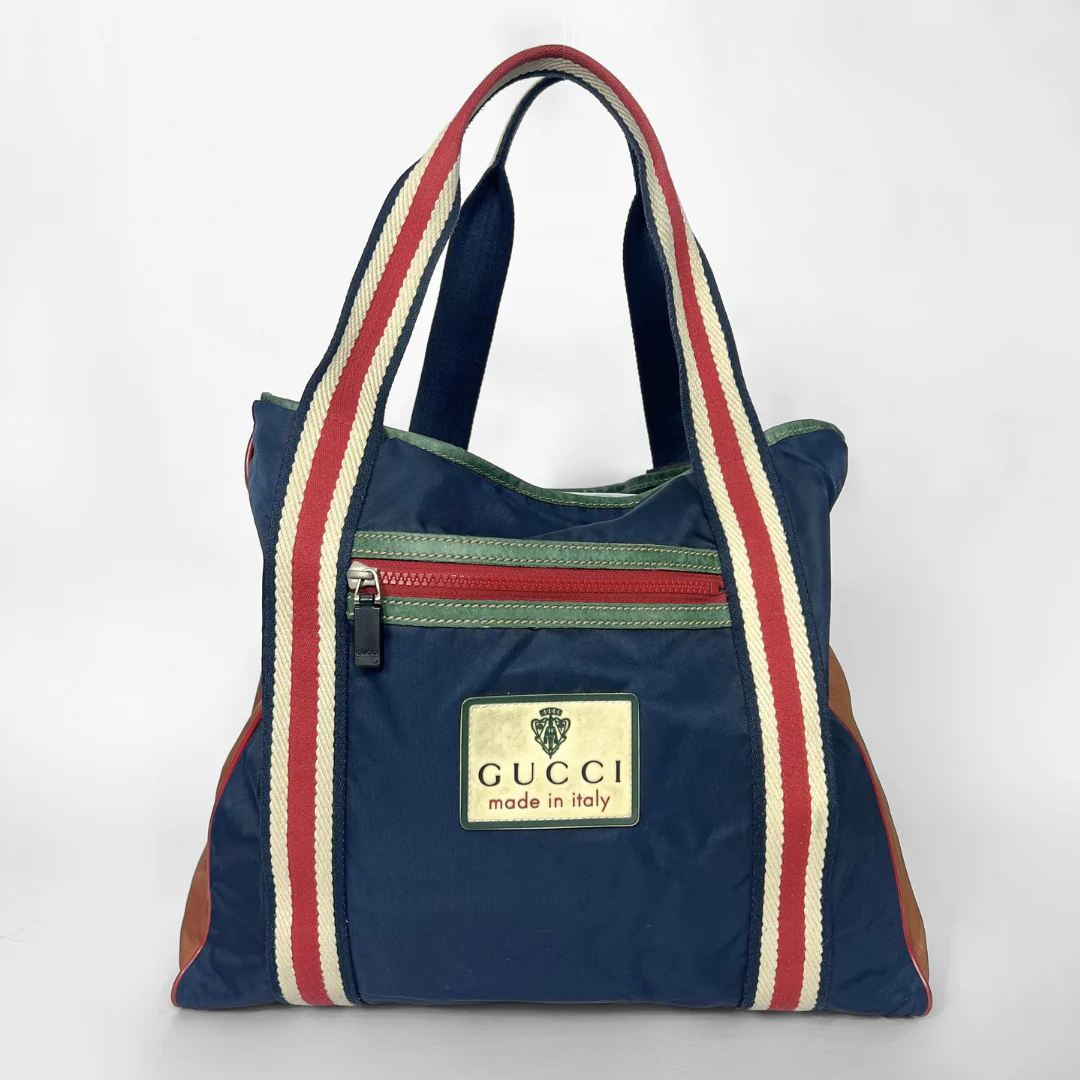 Navy blue tote bag with red and white stripes and Gucci logo on a white background