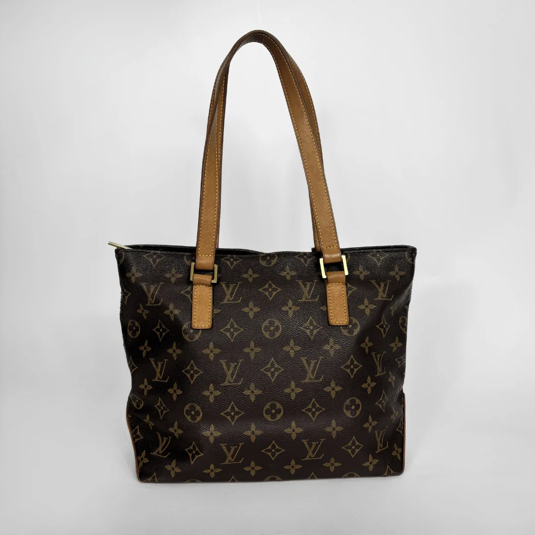 Louis Vuitton monogram canvas tote bag with tan leather shoulder straps and gold-tone hardware, photographed against a light gray studio background.