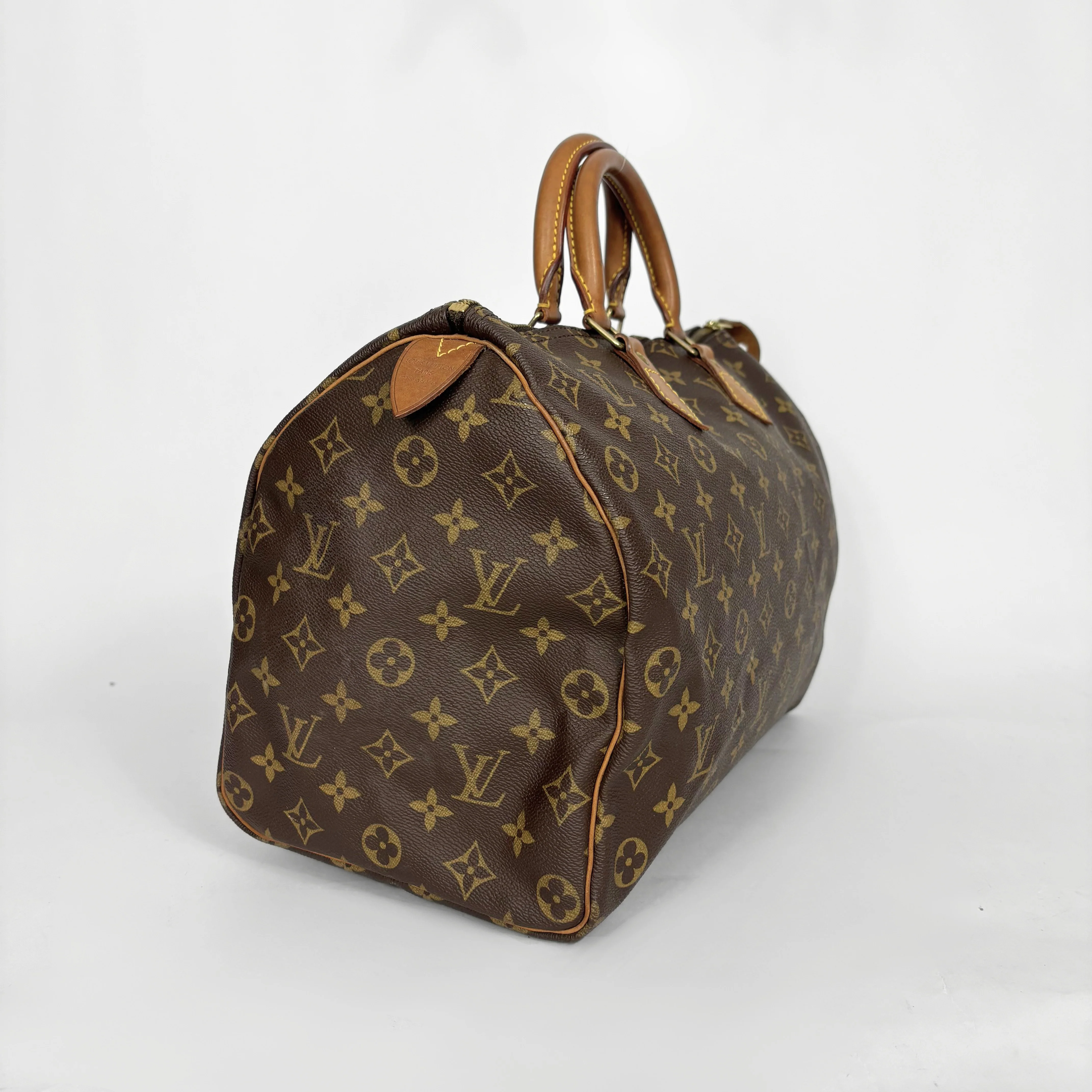Brown handbag with a monogram pattern on a white background