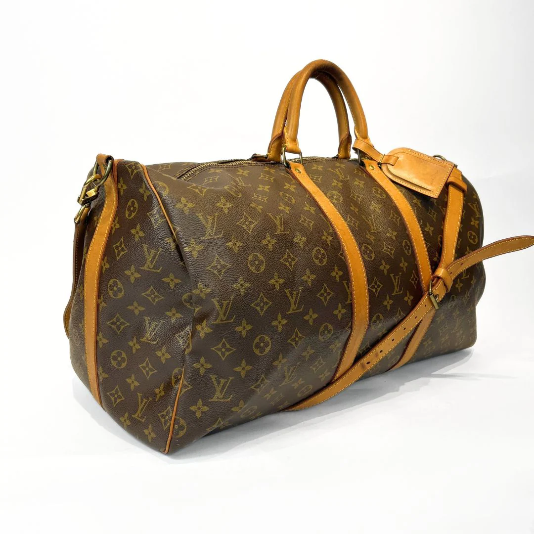 Brown travel bag with tan leather straps on a white background