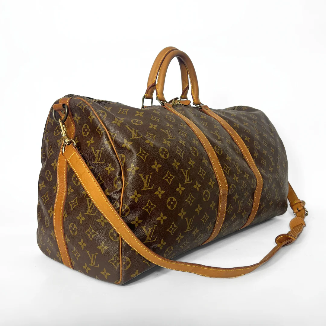 Brown duffel bag with tan leather accents on a white background