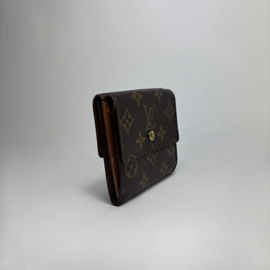 A Louis Vuitton monogram canvas wallet in dark brown with gold-tone hardware, photographed on a light gray studio background.