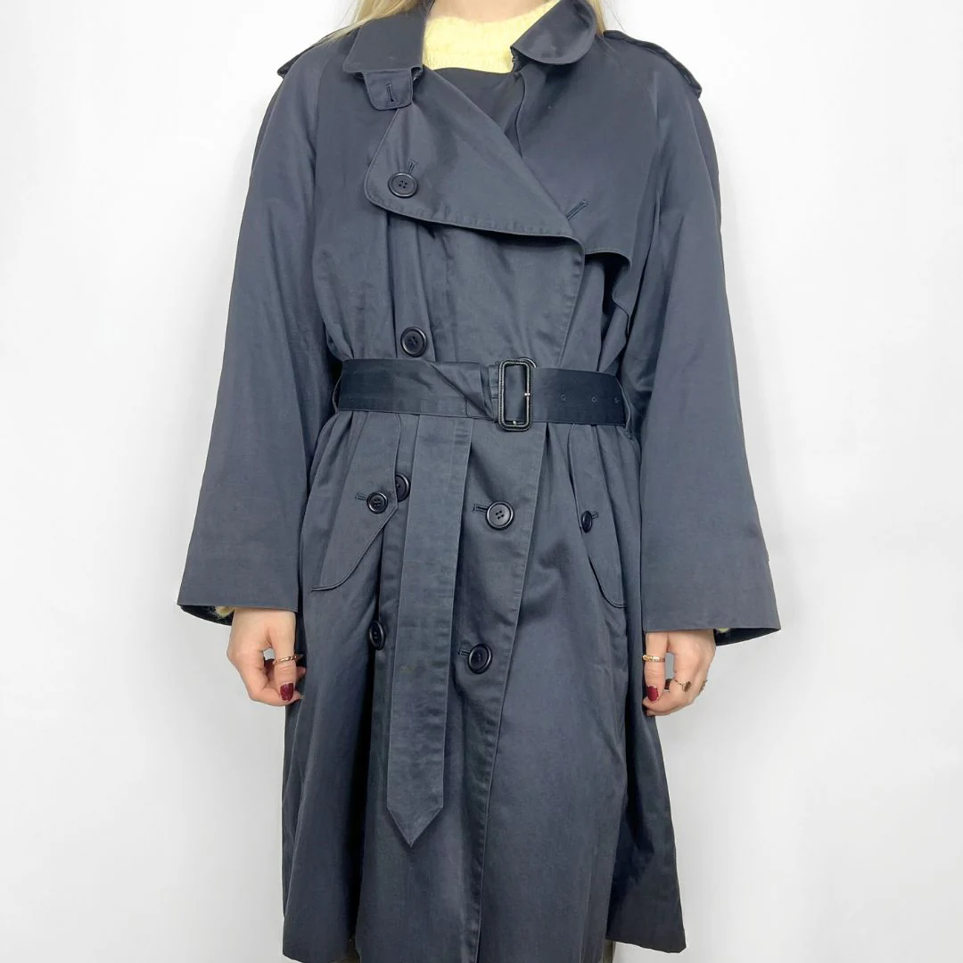 Gray trench coat worn by a person on a white background