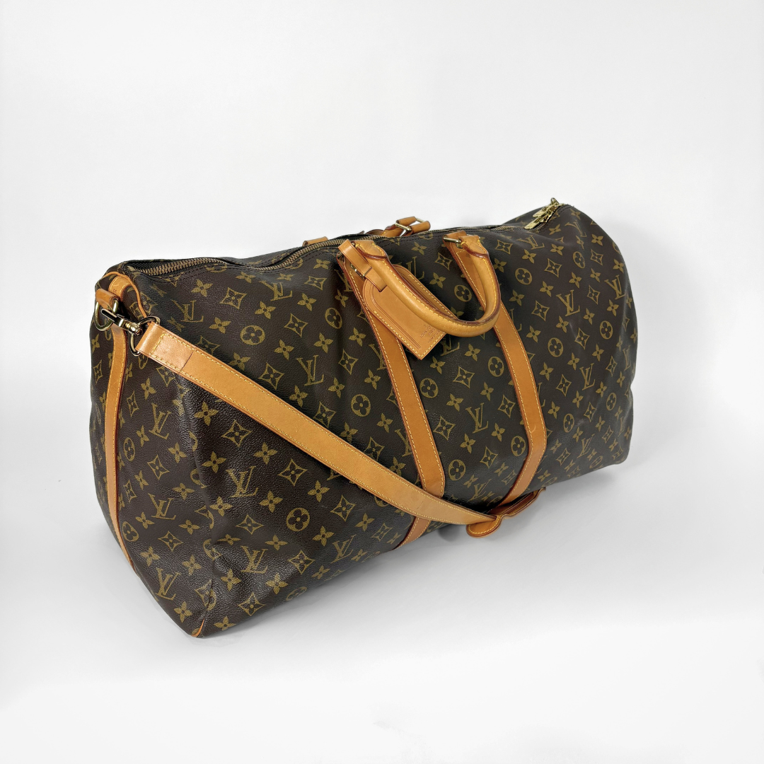 Brown monogram duffel bag with tan leather straps on a white background