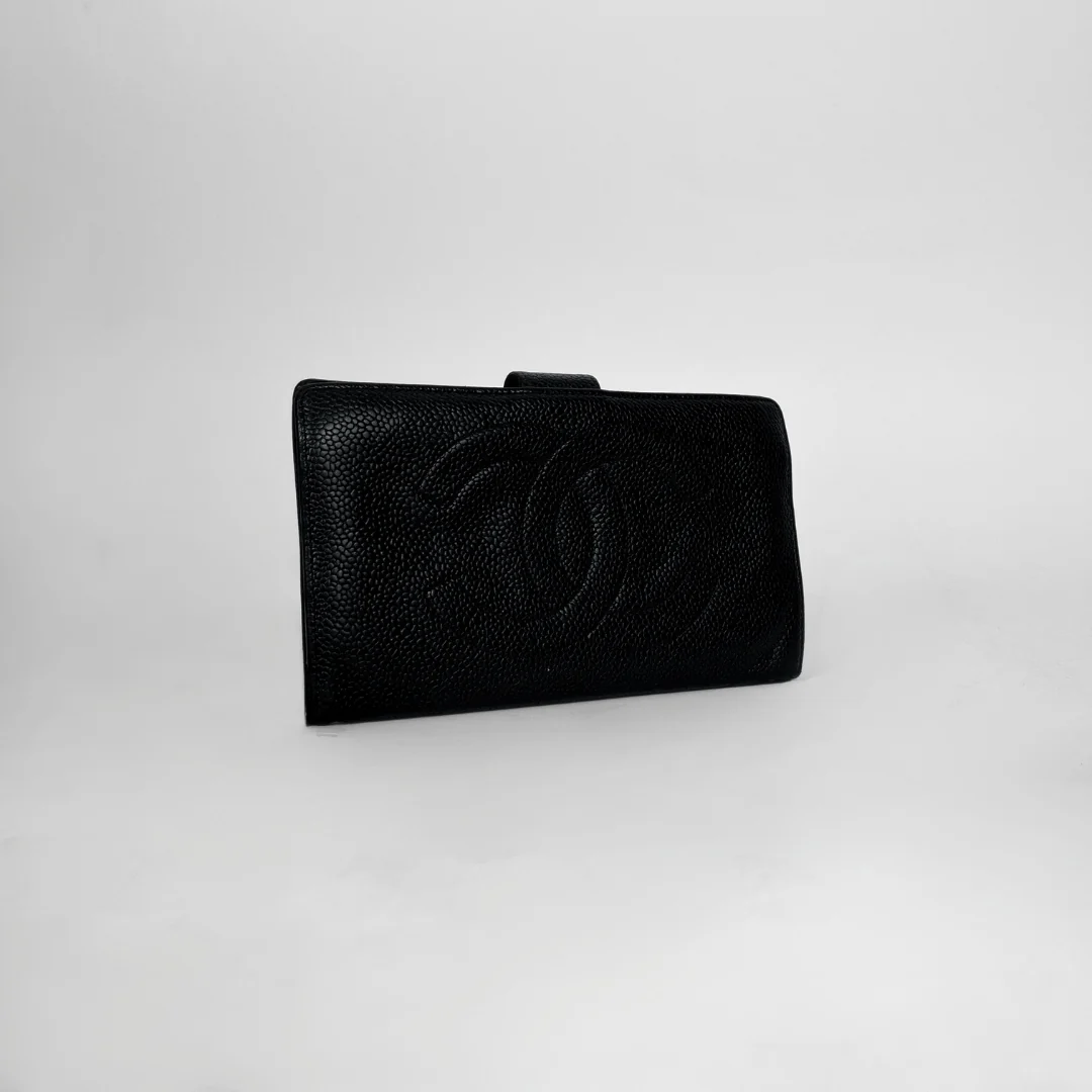 A black textured leather clutch bag with an embossed interlocking CC logo, characteristic of Chanel, set against a plain light gray background.