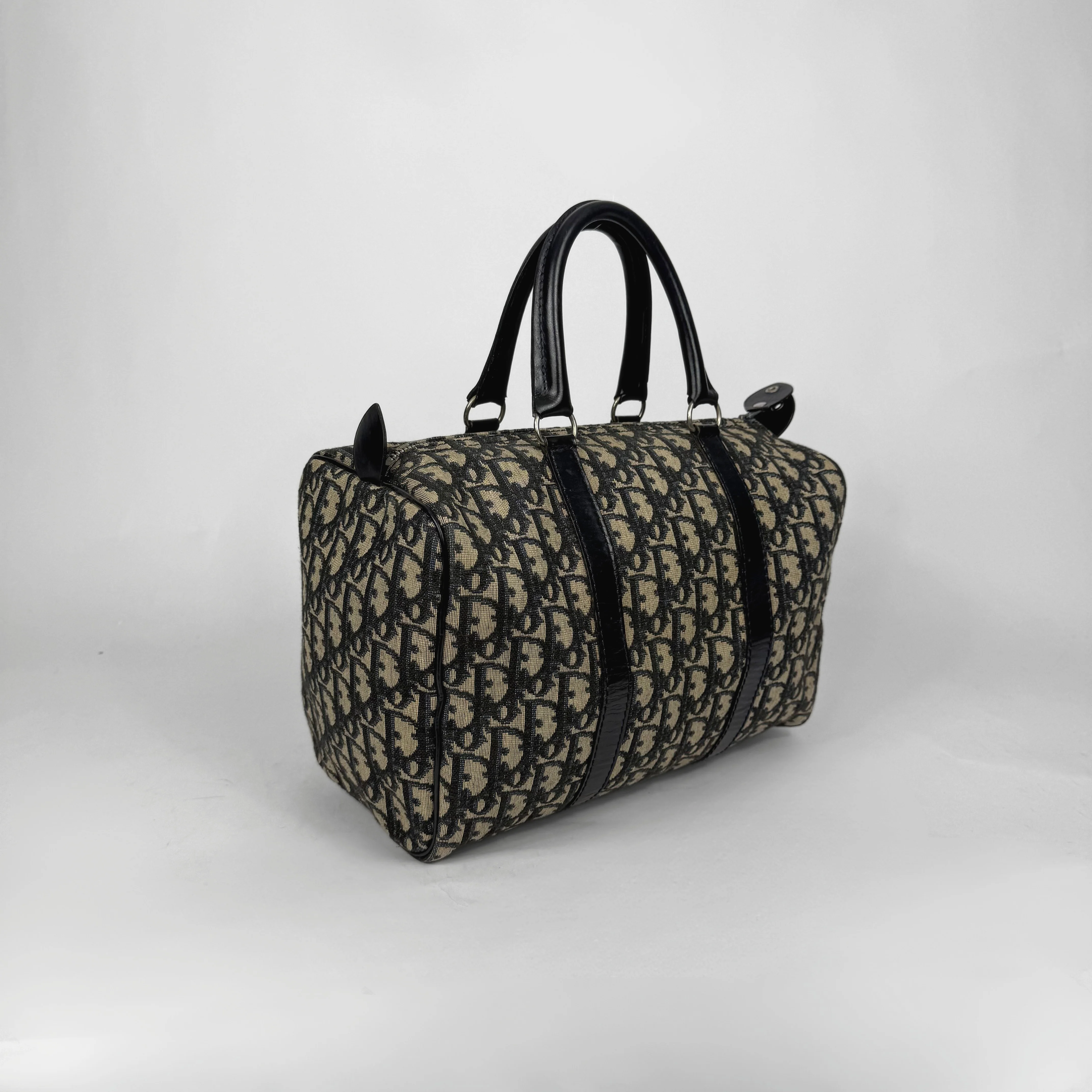 Designer handbag with a distinctive pattern on a light gray background