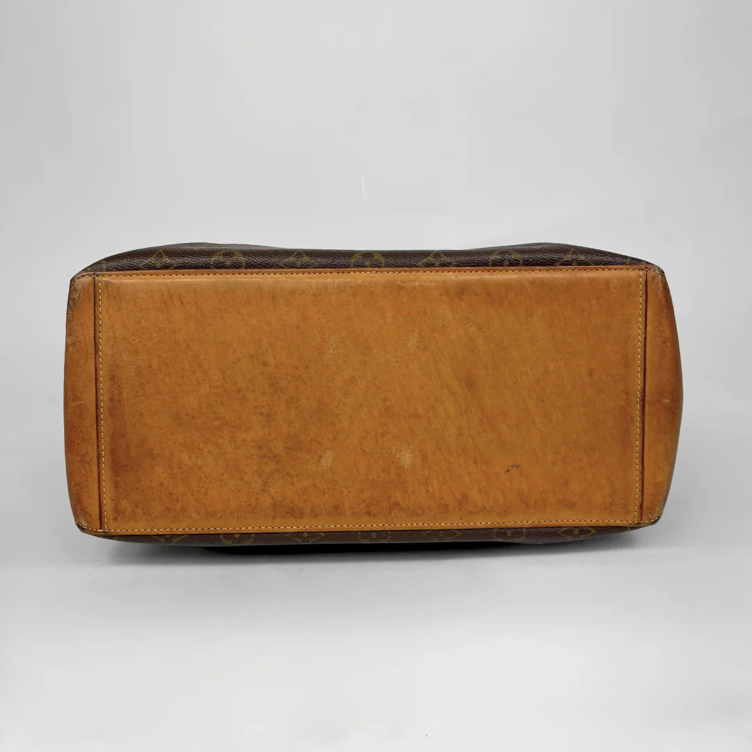 Brown leather bag with patterned top on a gray background