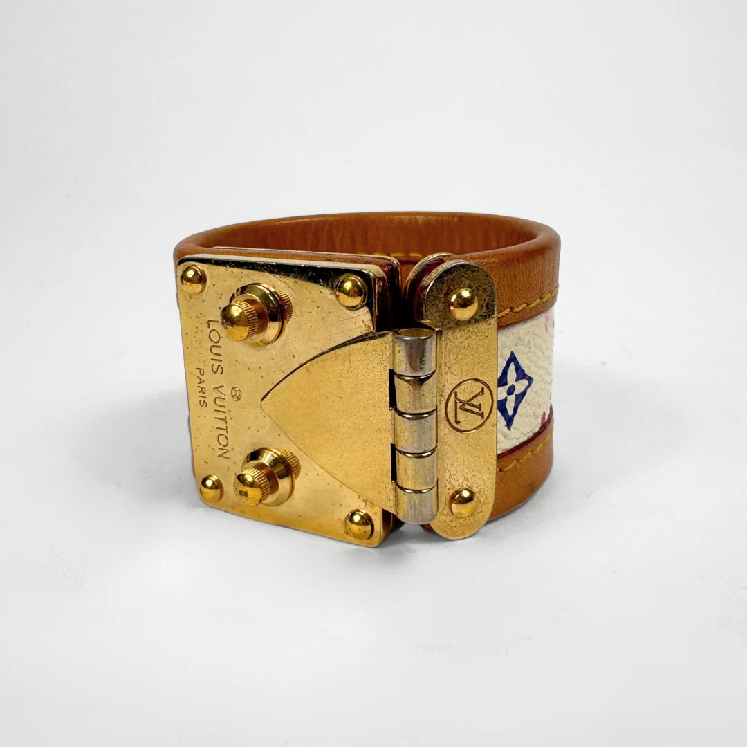 Gold and brown leather bracelet with hinge design on a white background