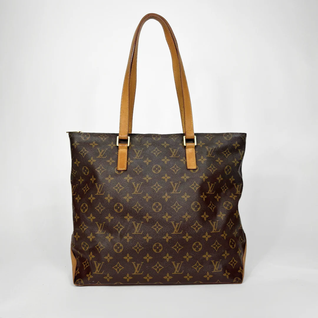 Brown monogram handbag with tan handles on a white background