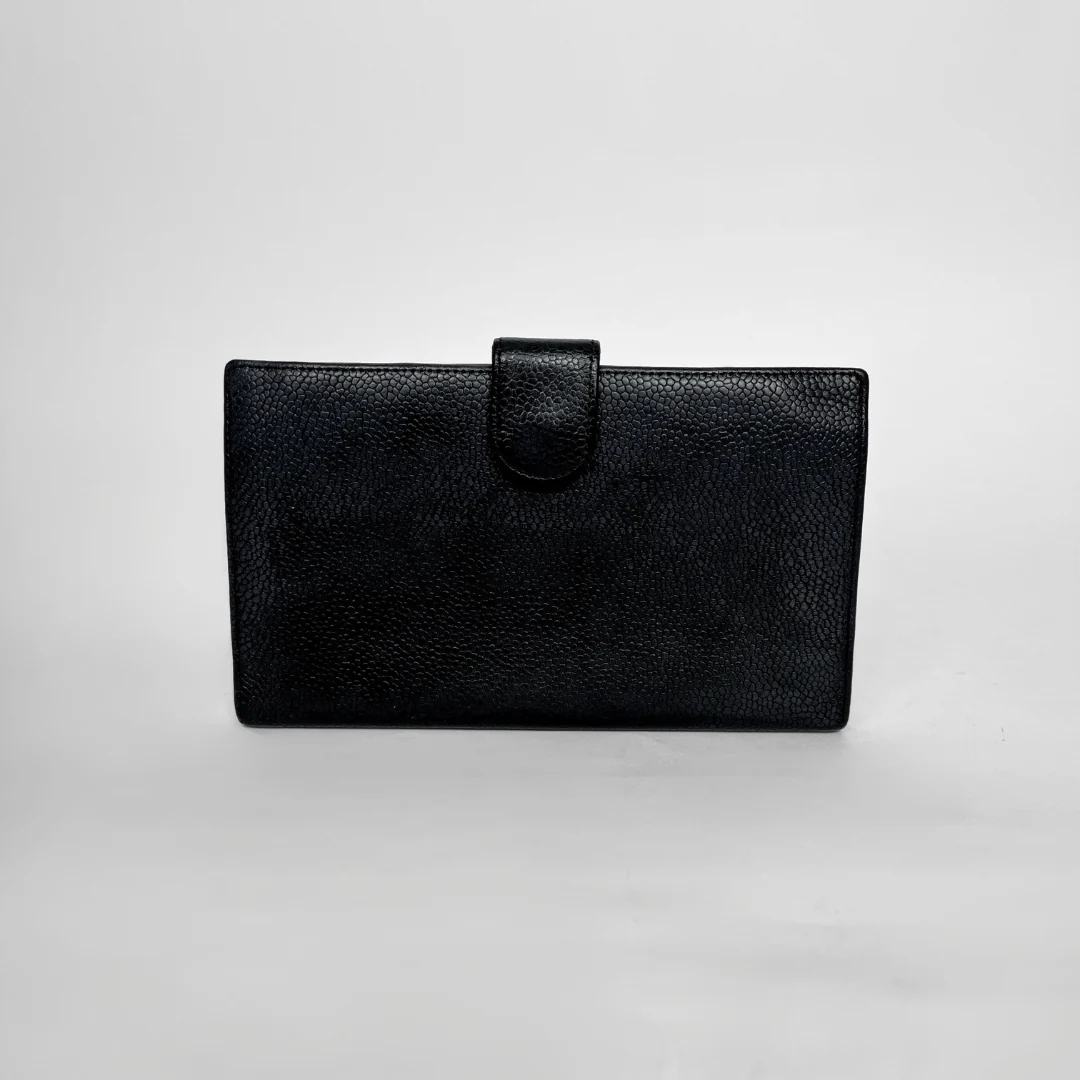 A black textured leather clutch wallet with a top strap closure, photographed against a neutral light gray background.
