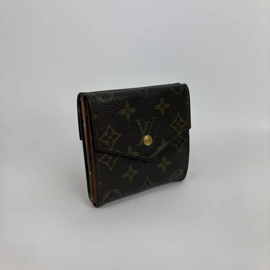 A classic Louis Vuitton monogram bifold wallet in dark brown coated canvas with gold-tone hardware, photographed on a neutral light gray background.