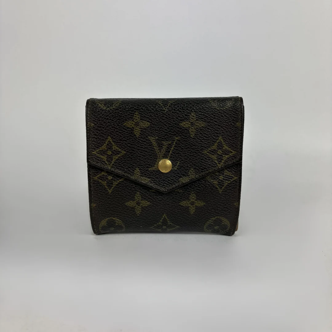 A Louis Vuitton monogram canvas bi-fold wallet in dark brown with gold-tone hardware, photographed against a neutral light gray background.